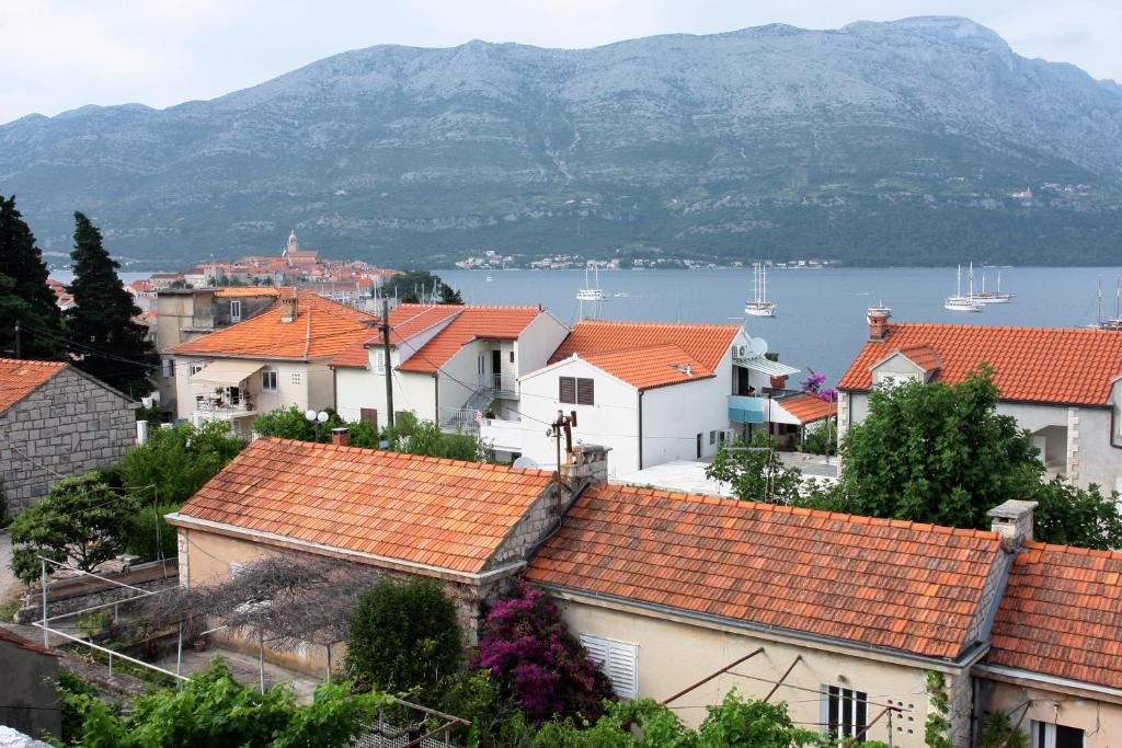 un grupo de casas con techos naranjas y una masa de agua en Apartment LuVi en Korčula