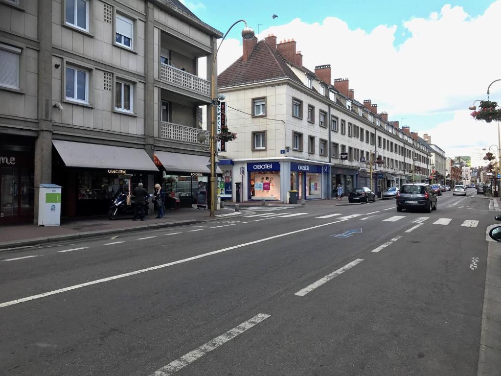 een lege straat met auto's die door de straat rijden bij Chez J&F in Elbeuf