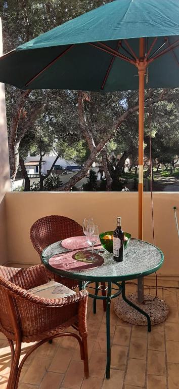- une table avec 2 verres à vin et un parasol dans l'établissement Estudios Nandy, à Es Pujols