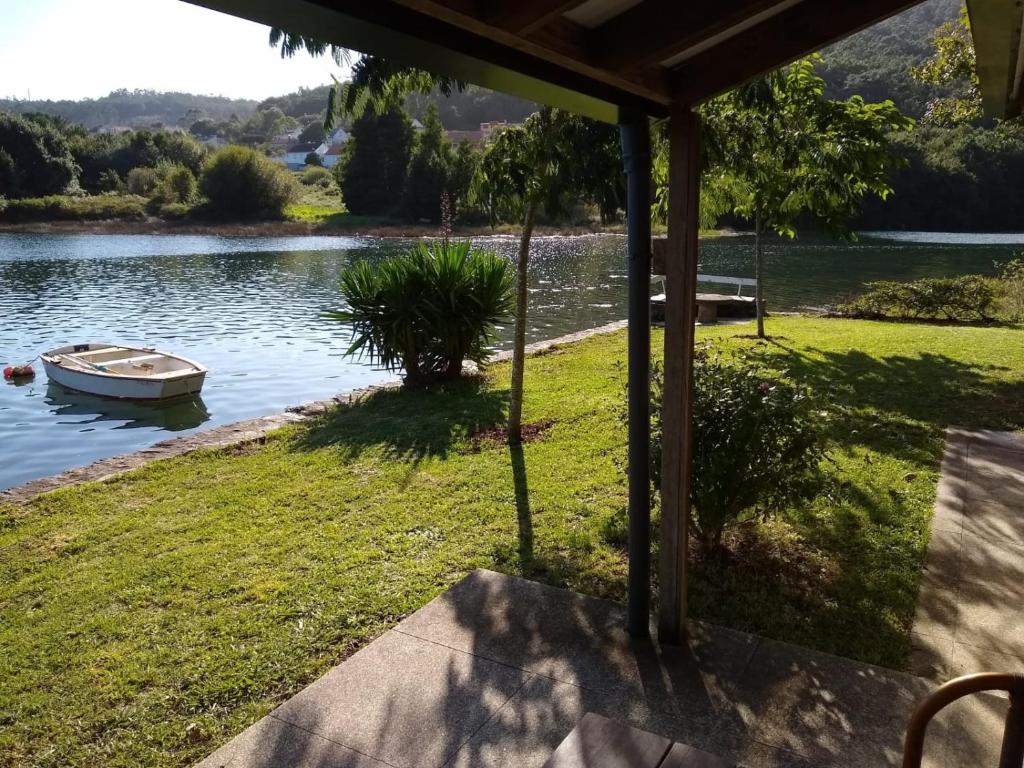 a boat in the water next to a lake at Casa con encanto en Muros, Esteiro in Solleiros