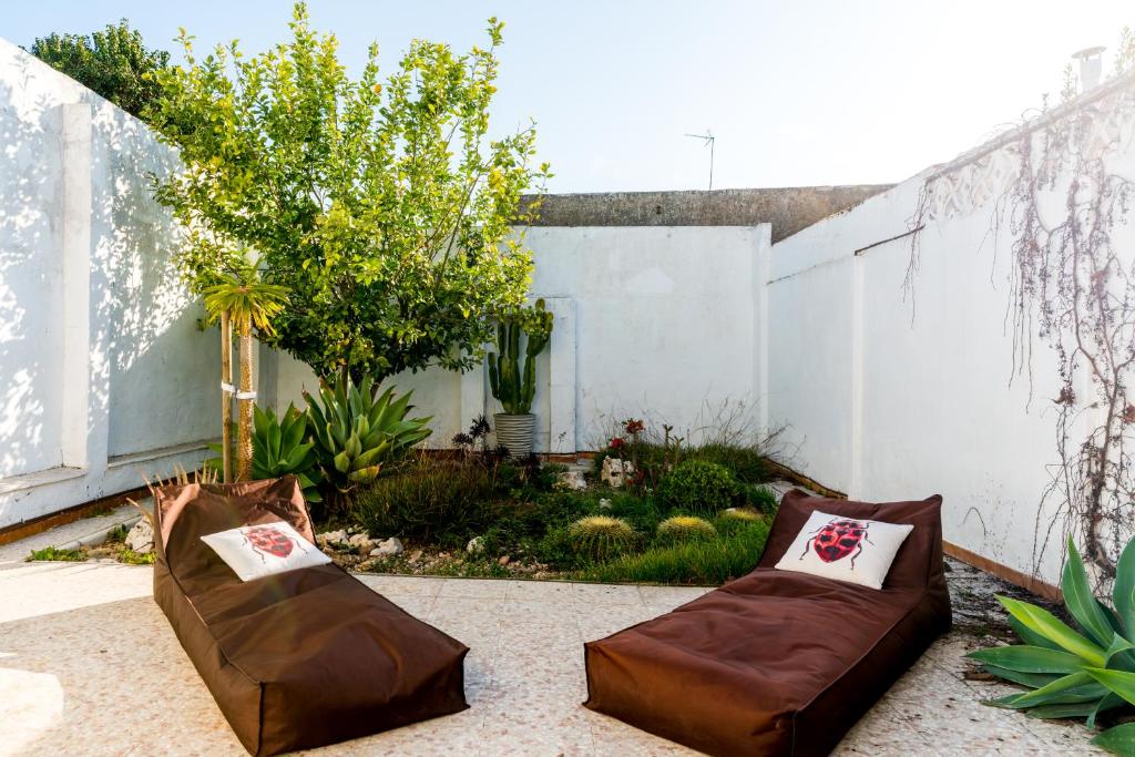 eine Terrasse mit zwei braunen Stühlen und einem Zaun in der Unterkunft Holi-Rent La Casa del Limonero in Castilleja de la Cuesta