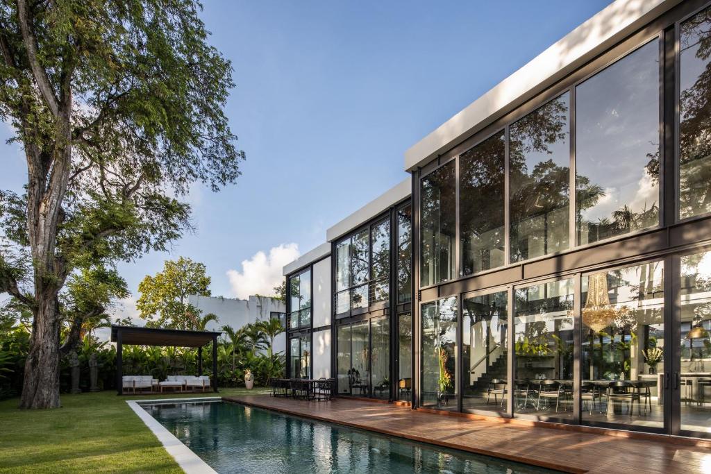 an exterior view of a building with a swimming pool at VILLA GIMA 1 - 5 bedroom UMALAS in Kerobokan