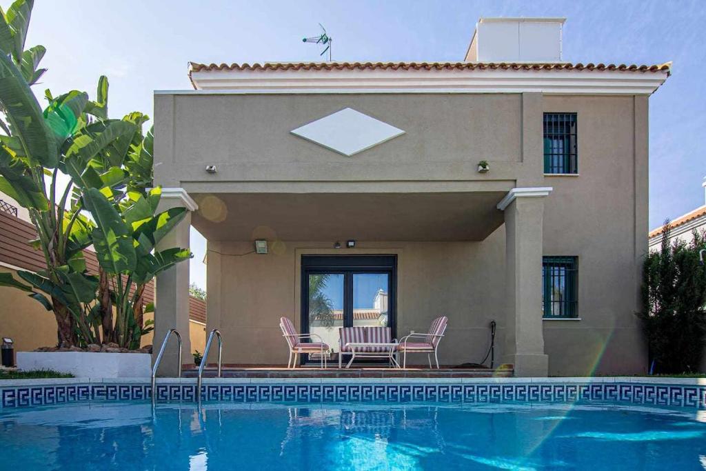 a house with a swimming pool in front of a house at Modern beach villa with parking and private pool in Torremolinos