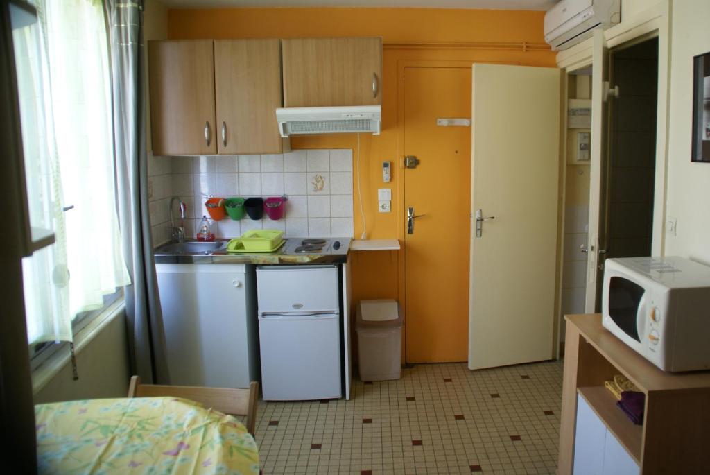a small kitchen with a sink and a microwave at Au Coeur de Bourg CSM in Courseulles-sur-Mer