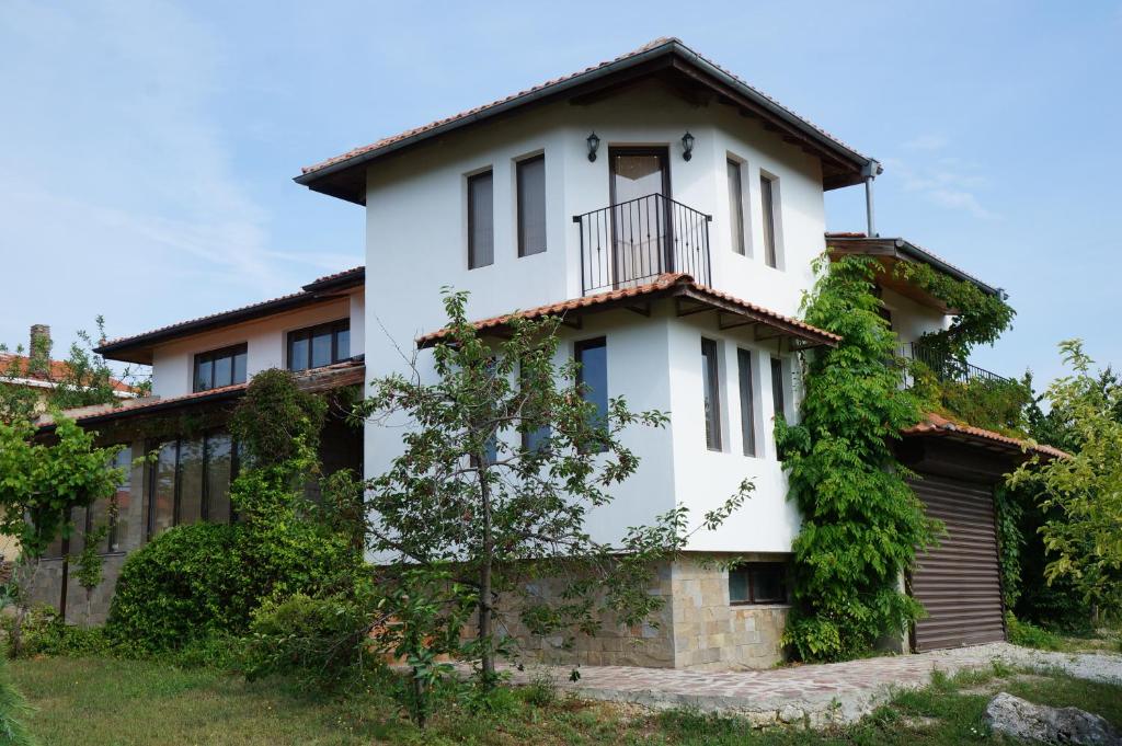 a white house with a balcony on top of it at Villa Bignonia in Varna City