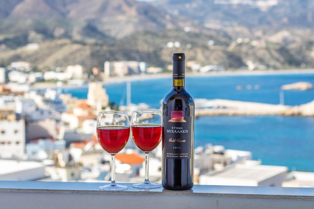 a bottle of wine and two glasses on a ledge at Divine Apartment in Karpathos