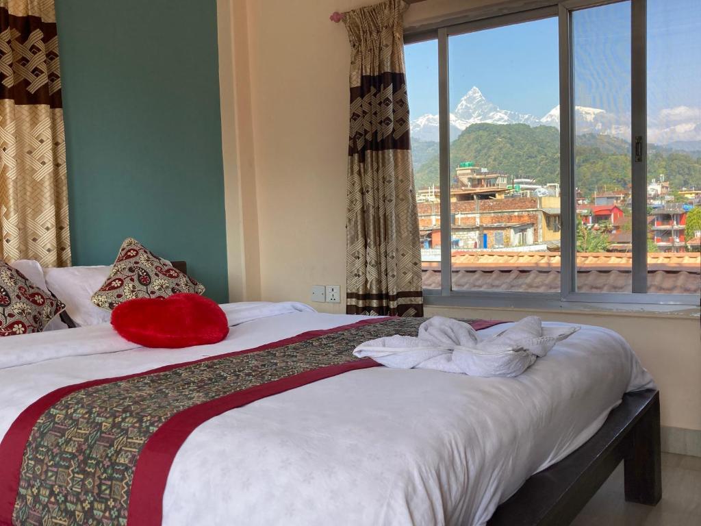 a bedroom with a bed with a view of a mountain at Hotel Nightingale in Pokhara