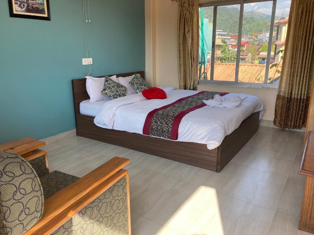 una camera da letto con un letto e una grande finestra di Hotel Nightingale a Pokhara