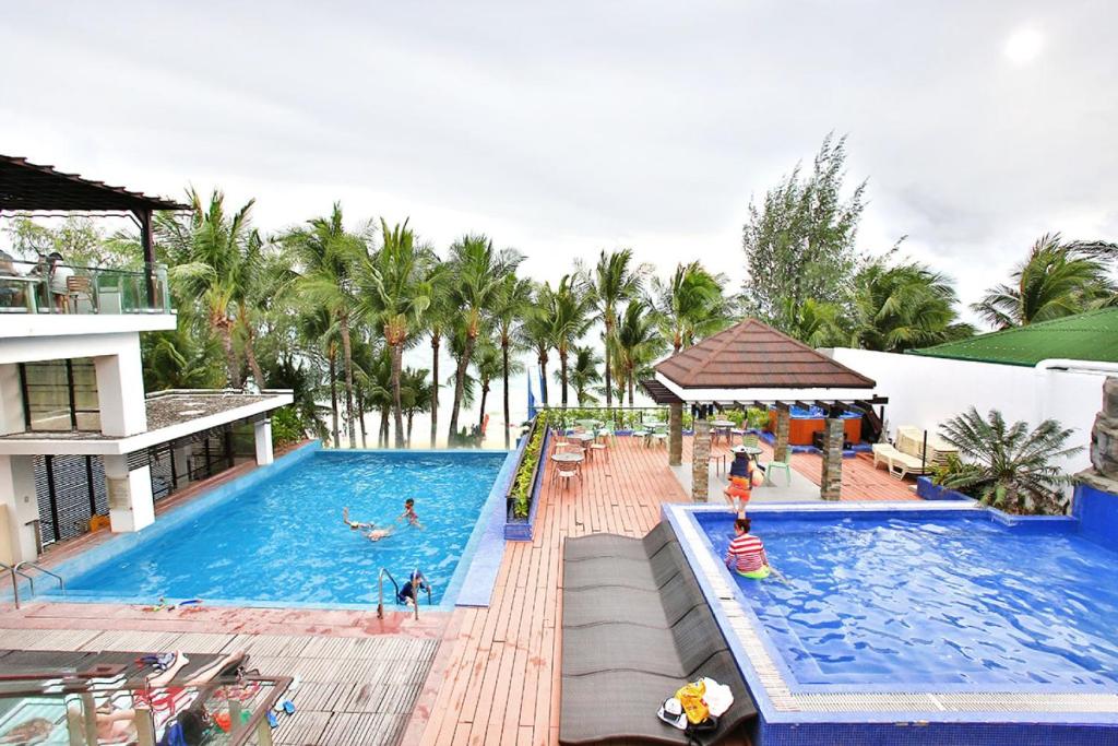 a swimming pool with people in the water at a resort at Crown Regency Beach Resort in Boracay