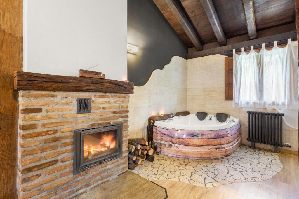 a living room with a fireplace and a tub at Casa Senderuela in Panzares