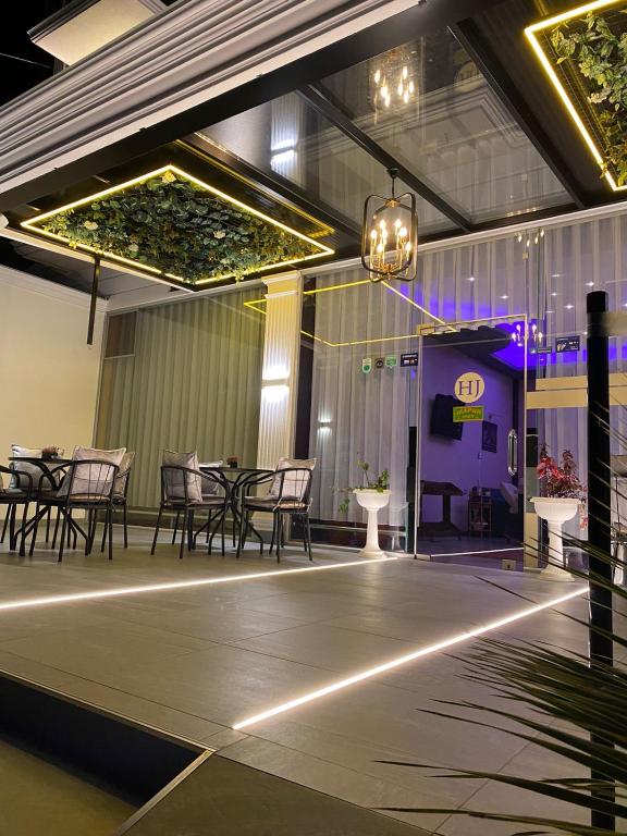 a stage with chairs and tables and a purple booth at Hotel Jurgen in Lezhë