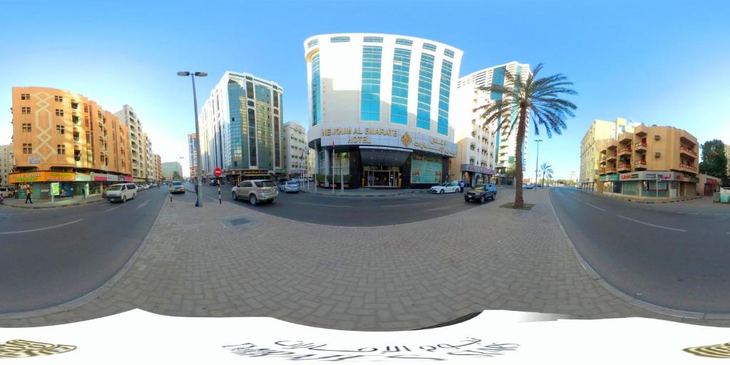 a city street with tall buildings and a skate park at Nejoum Al Emarat in Sharjah