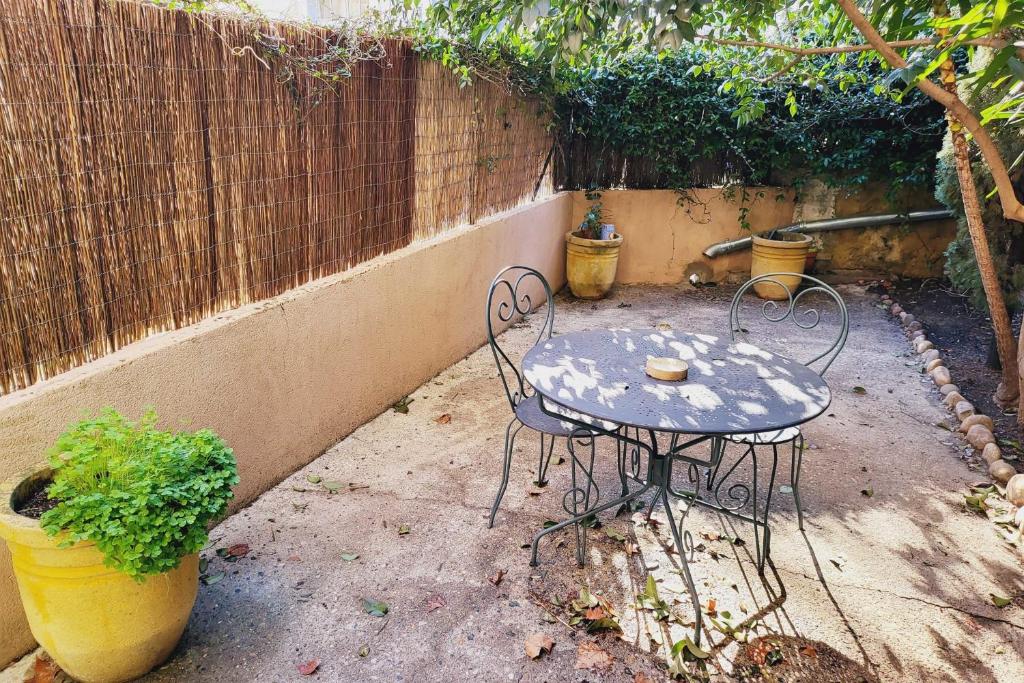 a table and chairs in a yard with a fence at STUDIO of 24m with small patio in Avignon
