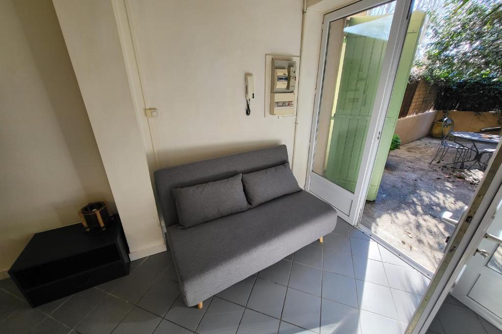 a gray couch sitting in the corner of a room at STUDIO of 24m with small patio in Avignon