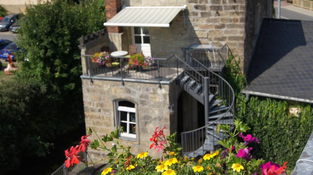 - un bâtiment avec un balcon fleuri dans l'établissement Ferienwohnung zur Steinburg, à Bad Schandau