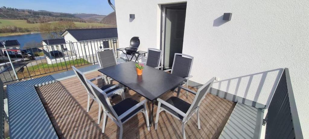 una mesa negra y sillas en el balcón en Sonnenweg 34, en Diemelsee