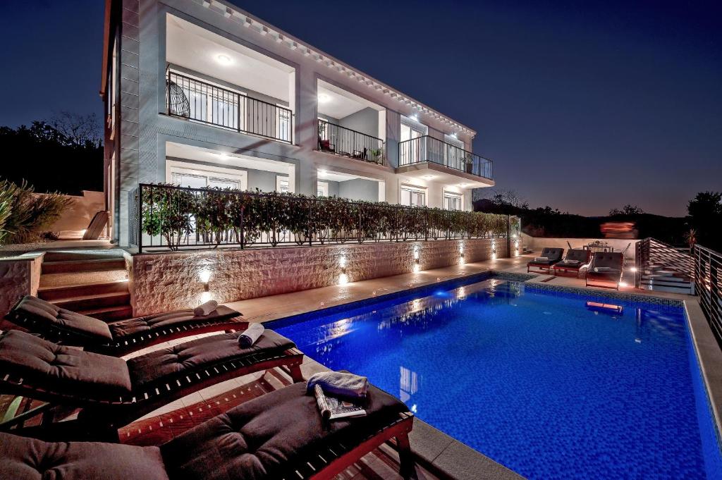 ein Haus mit einem Pool vor einem Gebäude in der Unterkunft Luxury Authentic Experience at Villa Marta in Lumbarda