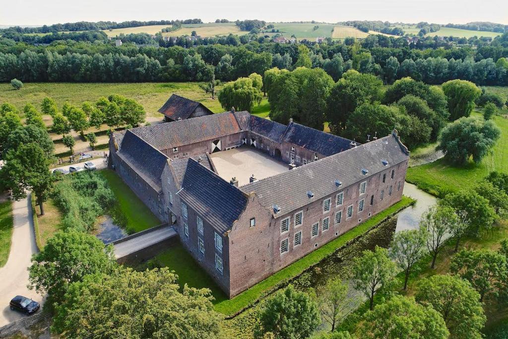 een luchtzicht op een oud gebouw in een veld bij Landgoed Kasteel Terborgh in Schinnen