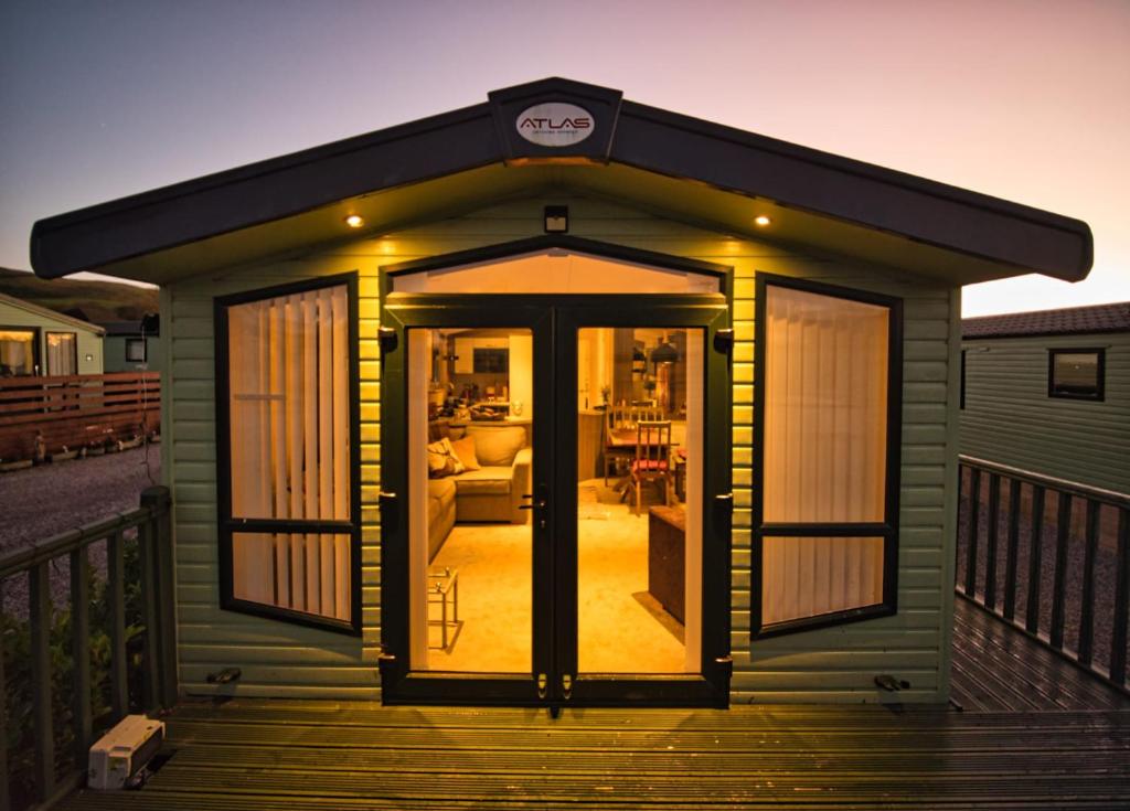 uma pequena casa com um alpendre e uma sala de estar em Bayfield em Lamplugh