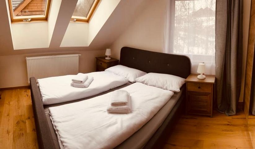 a bedroom with a bed with two towels on it at Apartmán SALD Mýto in Mýto pod Ďumbierom