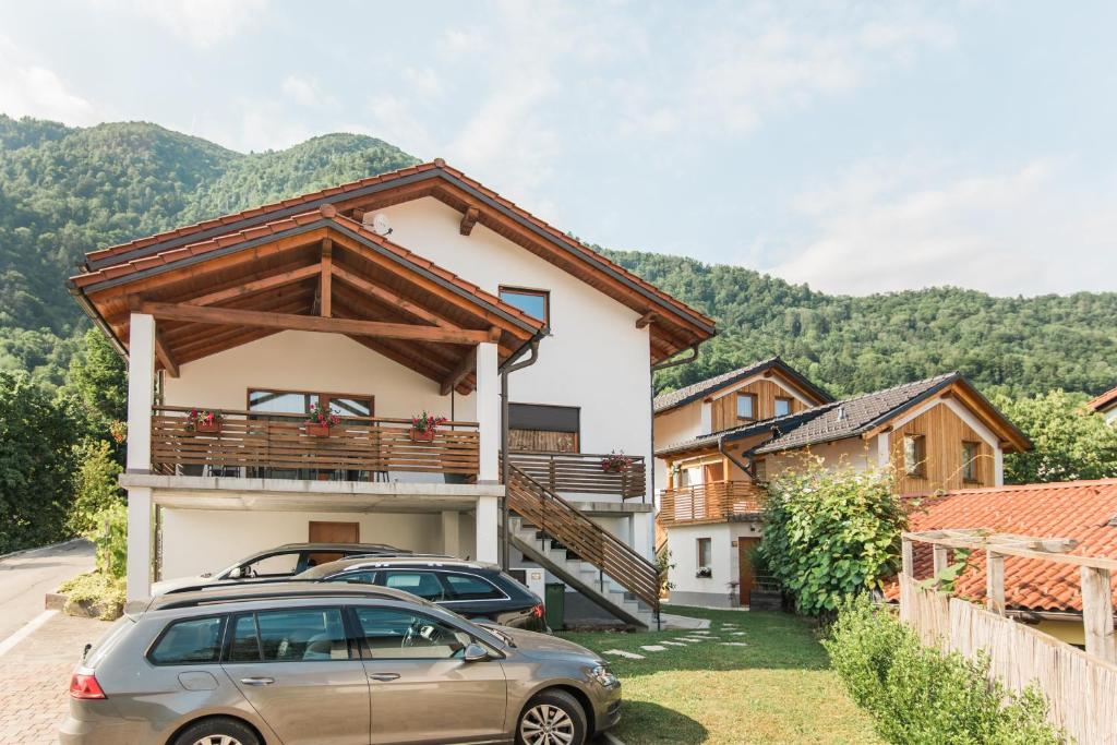 a house with two cars parked in front of it at Pr' Petrču in Tolmin