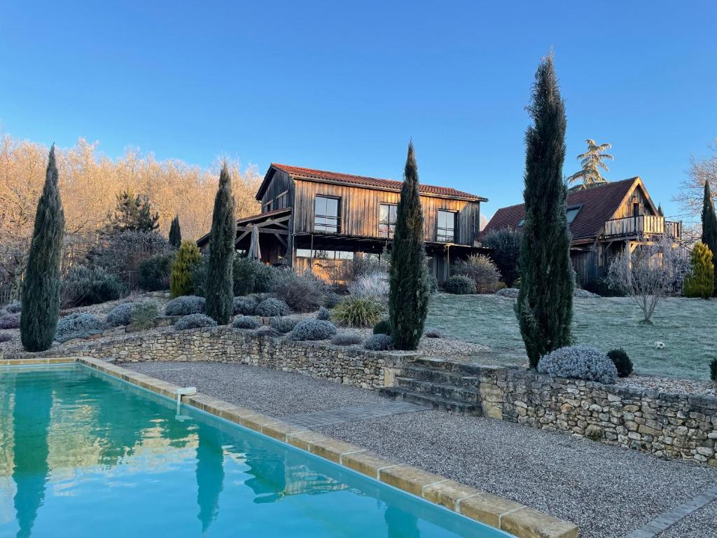 a home with a swimming pool in front of a house at Le Lion D'Or en PERIGORD in Mauzac-et-Grand-Castang