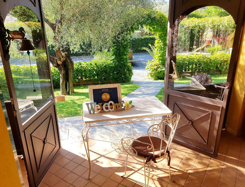 d'une porte ouverte sur un jardin avec une table et une fenêtre. dans l'établissement Salvia e Rosmarino - Affittacamere in Liguria, à Villanova dʼAlbenga