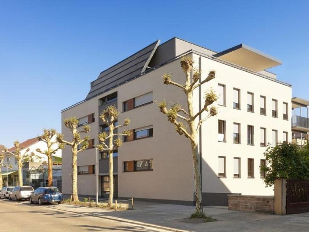 un edificio blanco con árboles delante de él en Hochburger.21, en Emmendingen