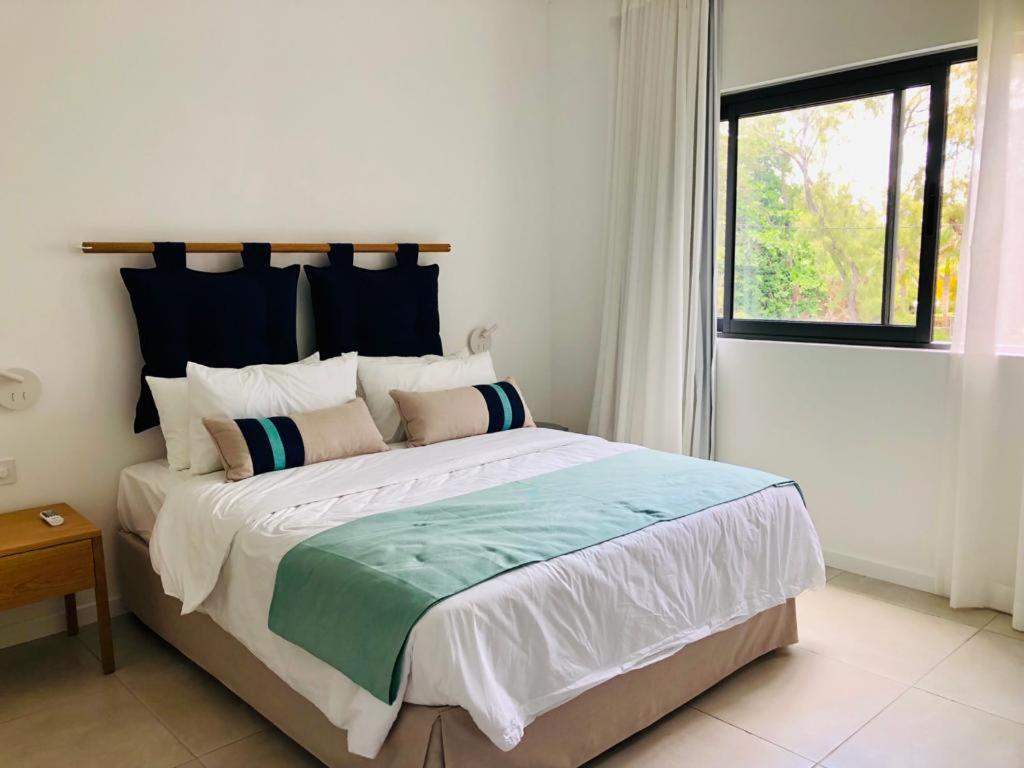 a bedroom with a large bed with a window at East Coast Beachfront Luxury - Eastern Blue Apartments in Poste Lafayette