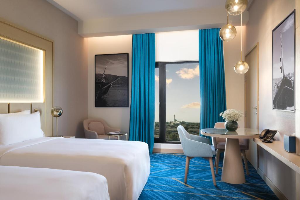 Postel nebo postele na pokoji v ubytování Maani Muscat Hotel & Suites