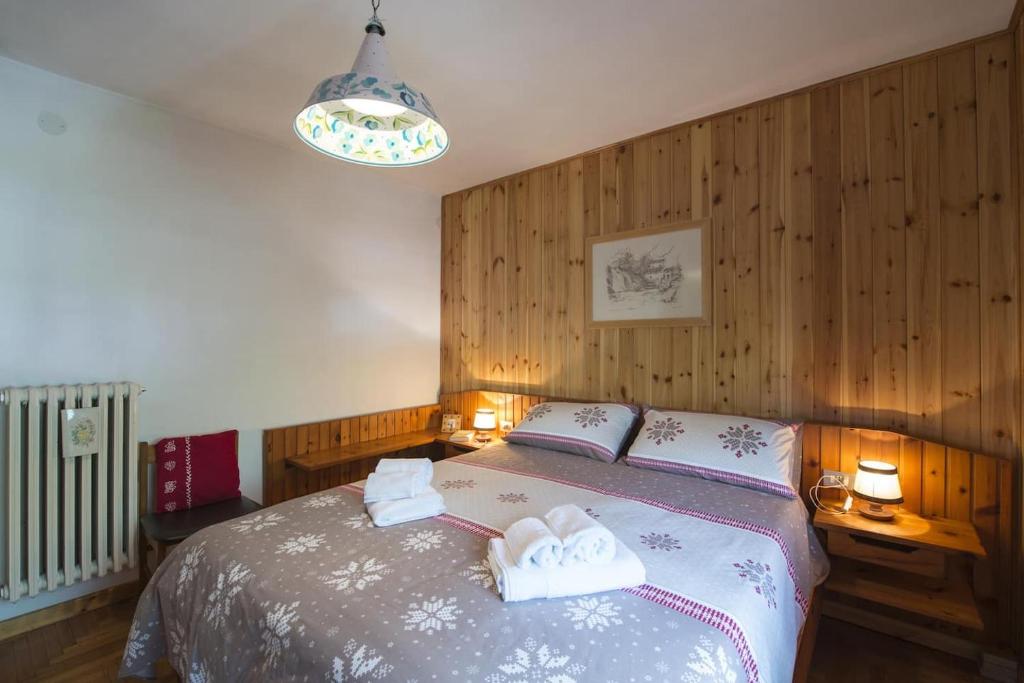 1 dormitorio con 1 cama con 2 toallas en Comfort Apartment Dimaro by Varental, en Dimaro