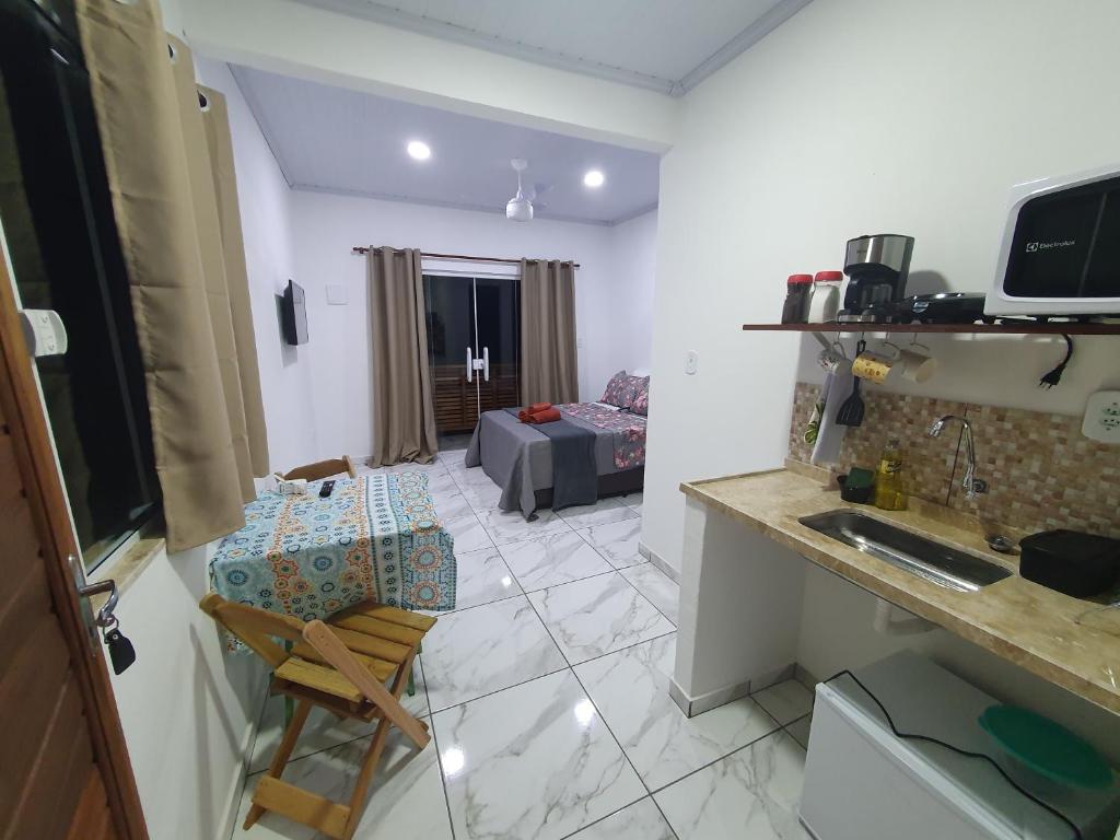 a room with a kitchen and a living room at Flat da Praia de Tarituba 1 in Paraty