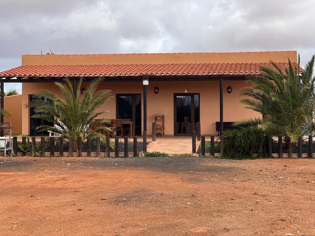 a house with palm trees in front of it at “La Cuadra” in Puerto del Rosario