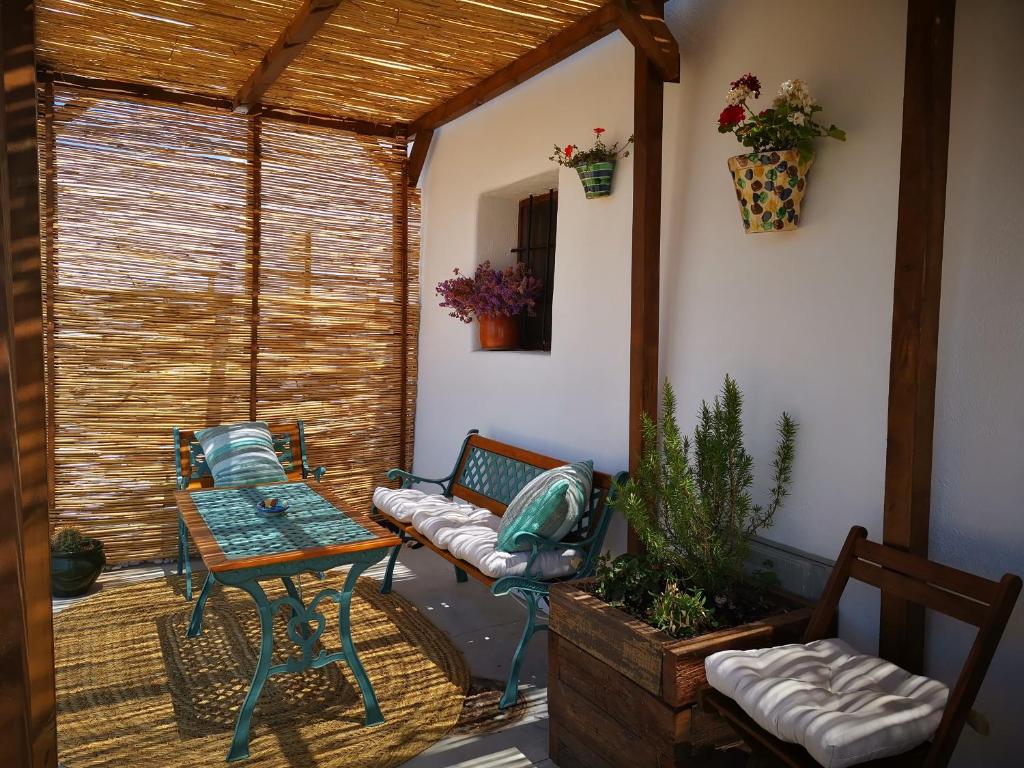 eine abgeschirmte Veranda mit einem Tisch und Stühlen in der Unterkunft Cortijo La Ciclona in Fernán Pérez