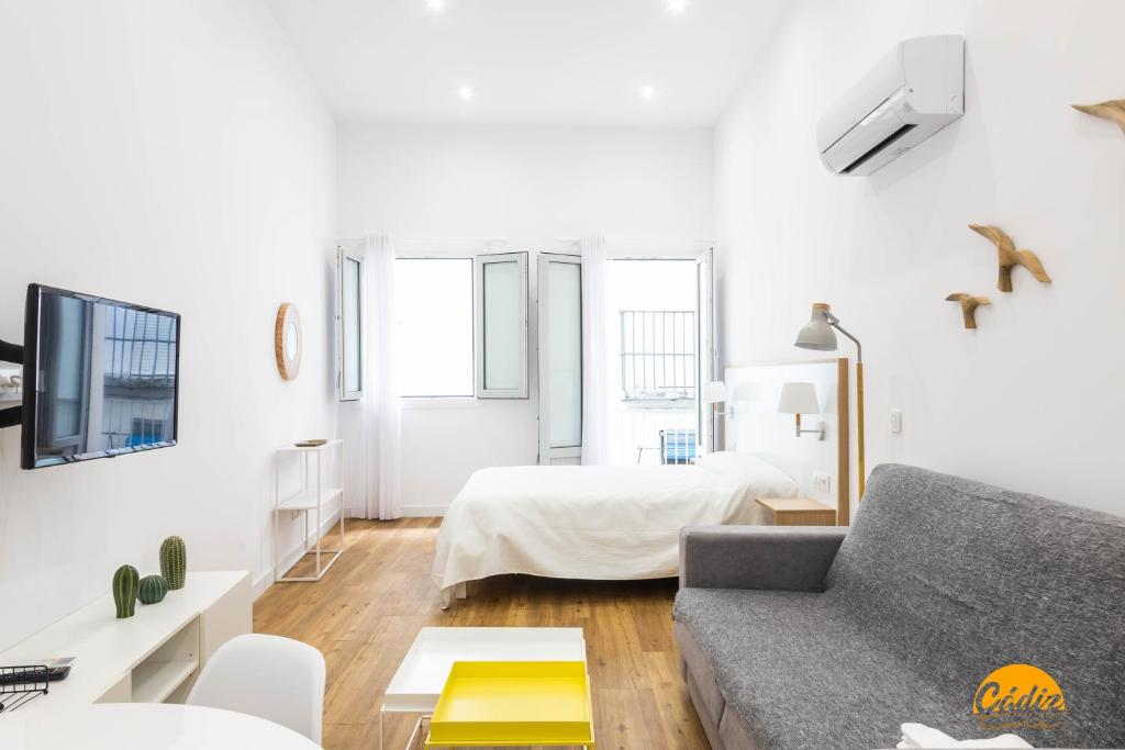uma sala de estar com um sofá e uma cama em Estudio Gaviota by Cadiz Time em Cádiz
