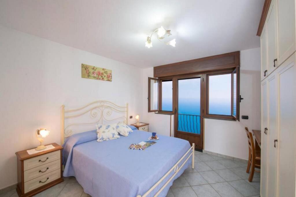 um quarto com uma cama e vista para o oceano em Il piccolo Sogno in costiera Amalfitana em Conca dei Marini