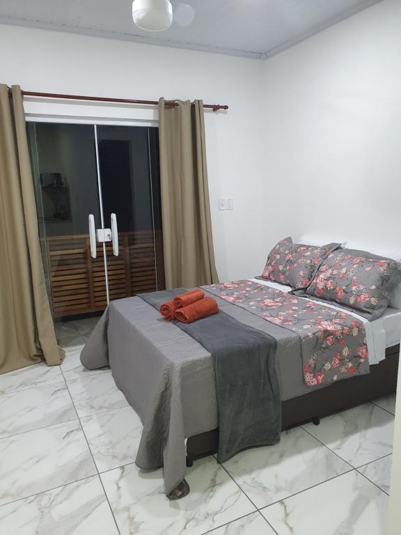 Un dormitorio con una cama y una ventana grande. en Flat da Praia de Tarituba 2, en Paraty