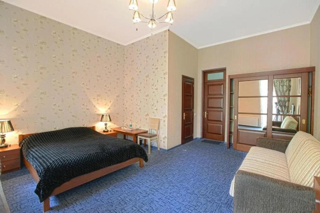 una camera con letto, scrivania e divano di Apart-Hotel next to Deribasivska a Odessa