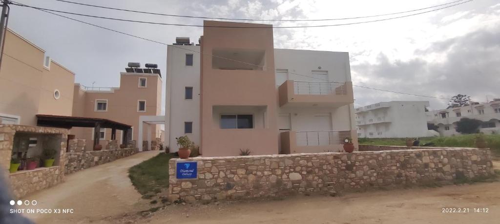 un edificio con una pared de piedra junto a una calle en Diamond Deluxe Apartments Mastichari en Mastichari