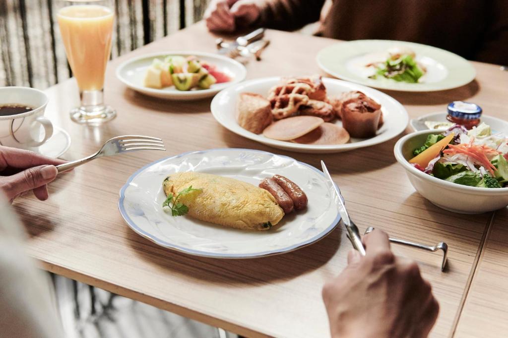 a wooden table with plates of food on it at ANA Crowne Plaza Kanazawa by IHG in Kanazawa