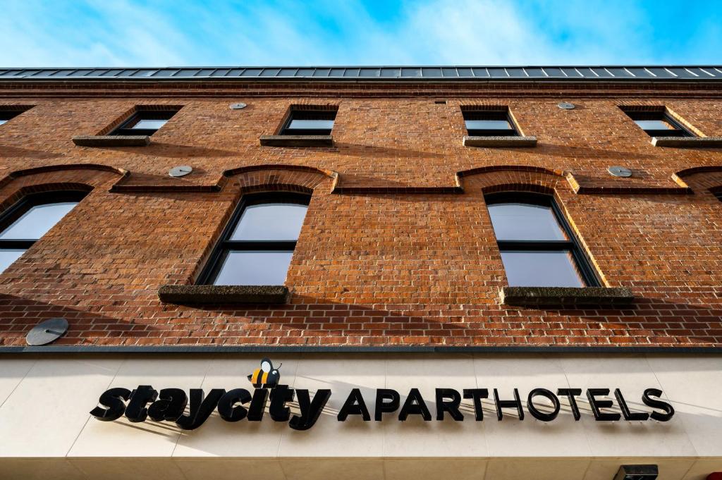 un edificio de ladrillo rojo con un cartel. en Staycity Aparthotels Dublin Tivoli en Dublín