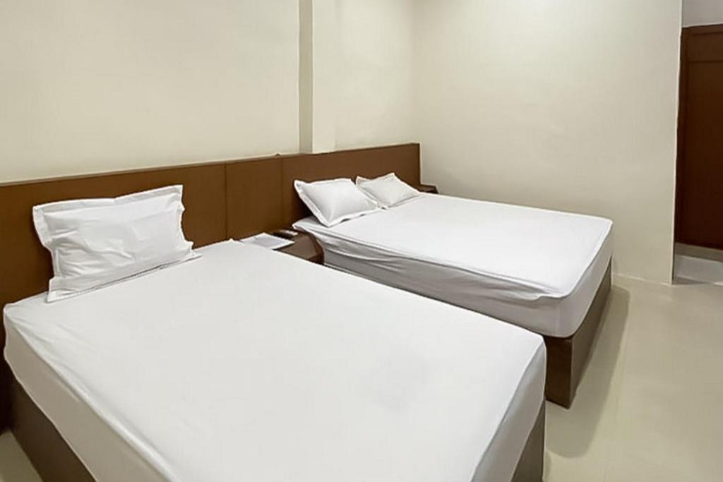 Voodi või voodid majutusasutuse Grand Emperom Hotel Mitra RedDoorz toas