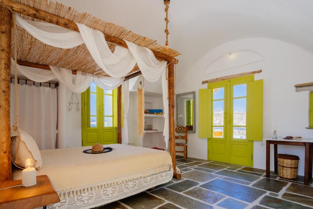 Schlafzimmer mit Himmelbett und grünen Türen in der Unterkunft Stenosa in Donousa