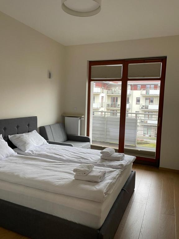 a large bed in a room with a large window at Summer - Neptun Park by OneApartments in Gdańsk