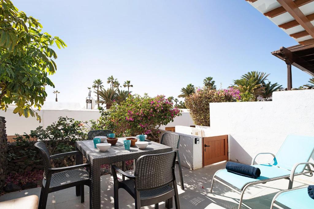 patio con mesa y sillas en el balcón en Bungalow Flamingo, en Playa Blanca