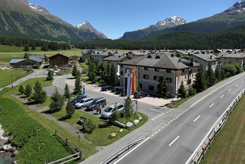 Luftblick auf eine Stadt mit Straße und Bergen in der Unterkunft Hotel Saluver in Celerina