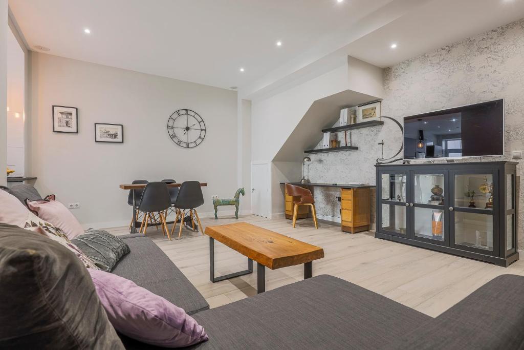 salon z kanapą i stołem w obiekcie Minimalismo de Vanguardia con altas calidades 1 BR w Sewilli