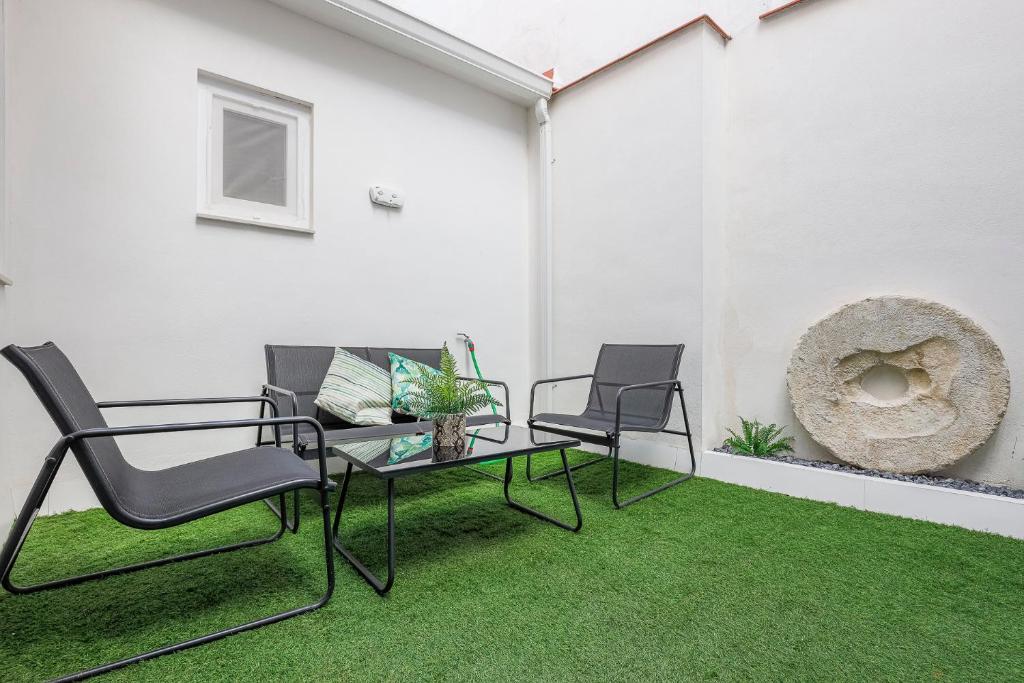 patio z 2 krzesłami, stołem i trawą w obiekcie Minimalismo de Vanguardia con altas calidades 1 BR w Sewilli