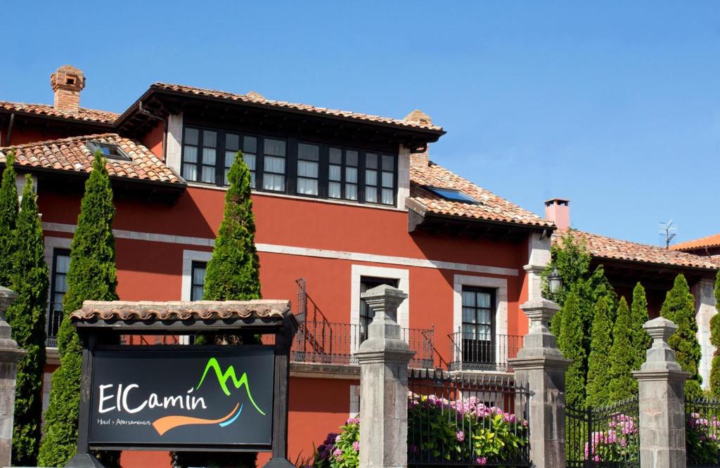 a house with a sign in front of it at Hotel y Apartamentos El Camín in poo de Llanes