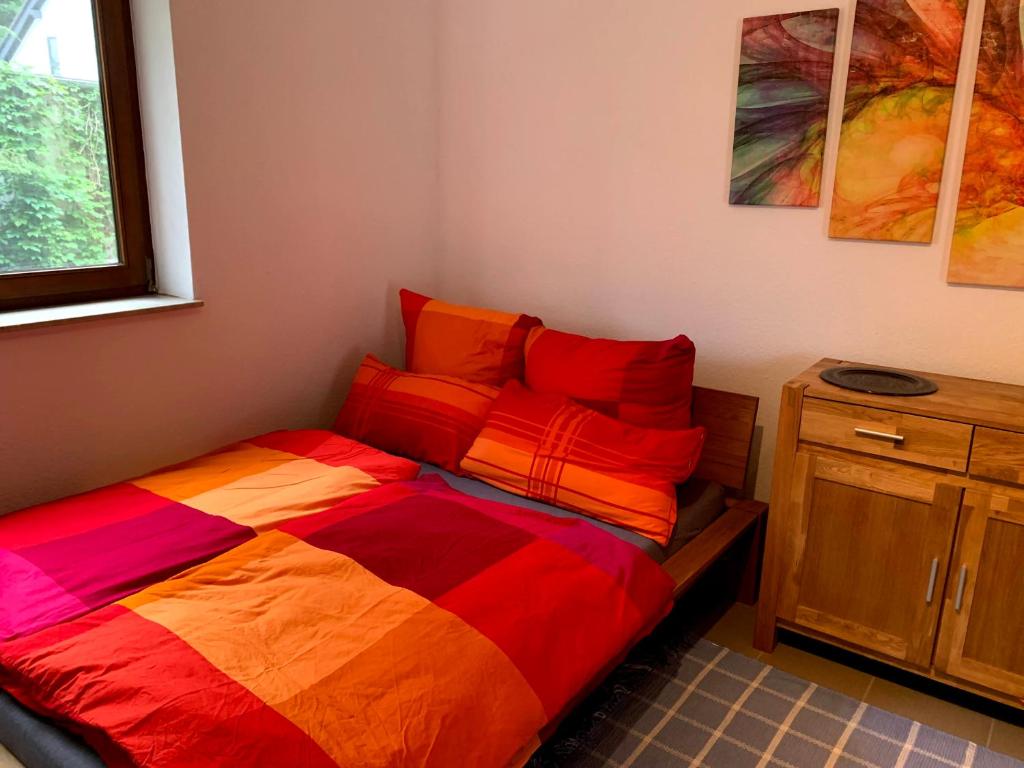 a bedroom with a bed with a colorful comforter at Ferienwohnung Monteuerswohnung am Bauernhofweg in Lohmar nahe S-Bahnhof in Lohmar